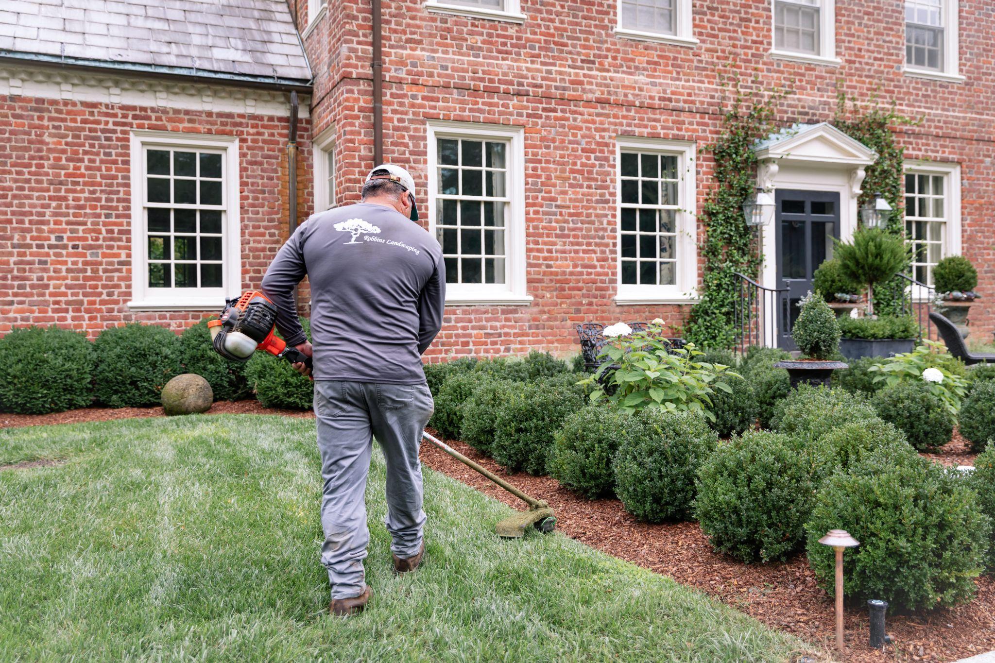 Landscape professional edging lawn and shrub beds at a residential property